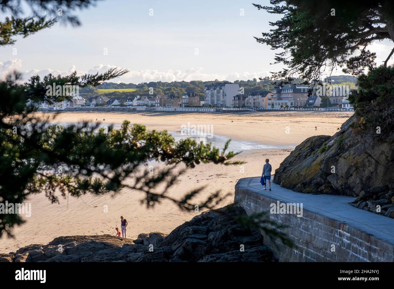 Saint-Cast-le-Guildo (Bretagna, Francia nord-occidentale): La zona costiera “Cote d’Emeraude”, camminatore su un sentiero e panoramica della spiaggia principale con buildi Foto Stock