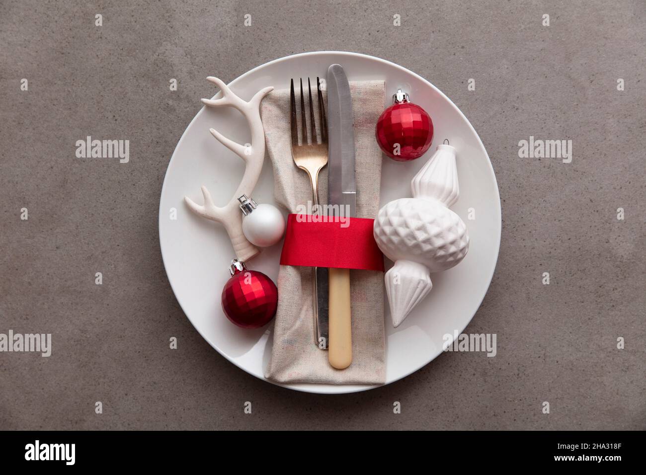 Cena natalizia di sottofondo. Piatto con coltello e forchetta e decorazioni natalizie Foto Stock
