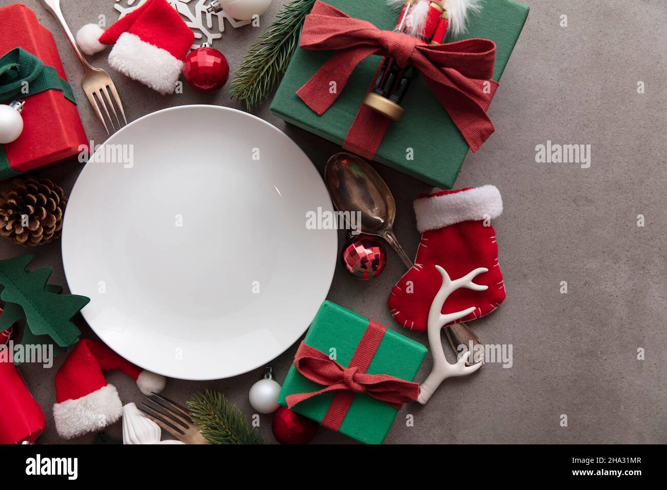 Cena natalizia di sottofondo. Piatto bianco vuoto con decorazioni natalizie Foto Stock