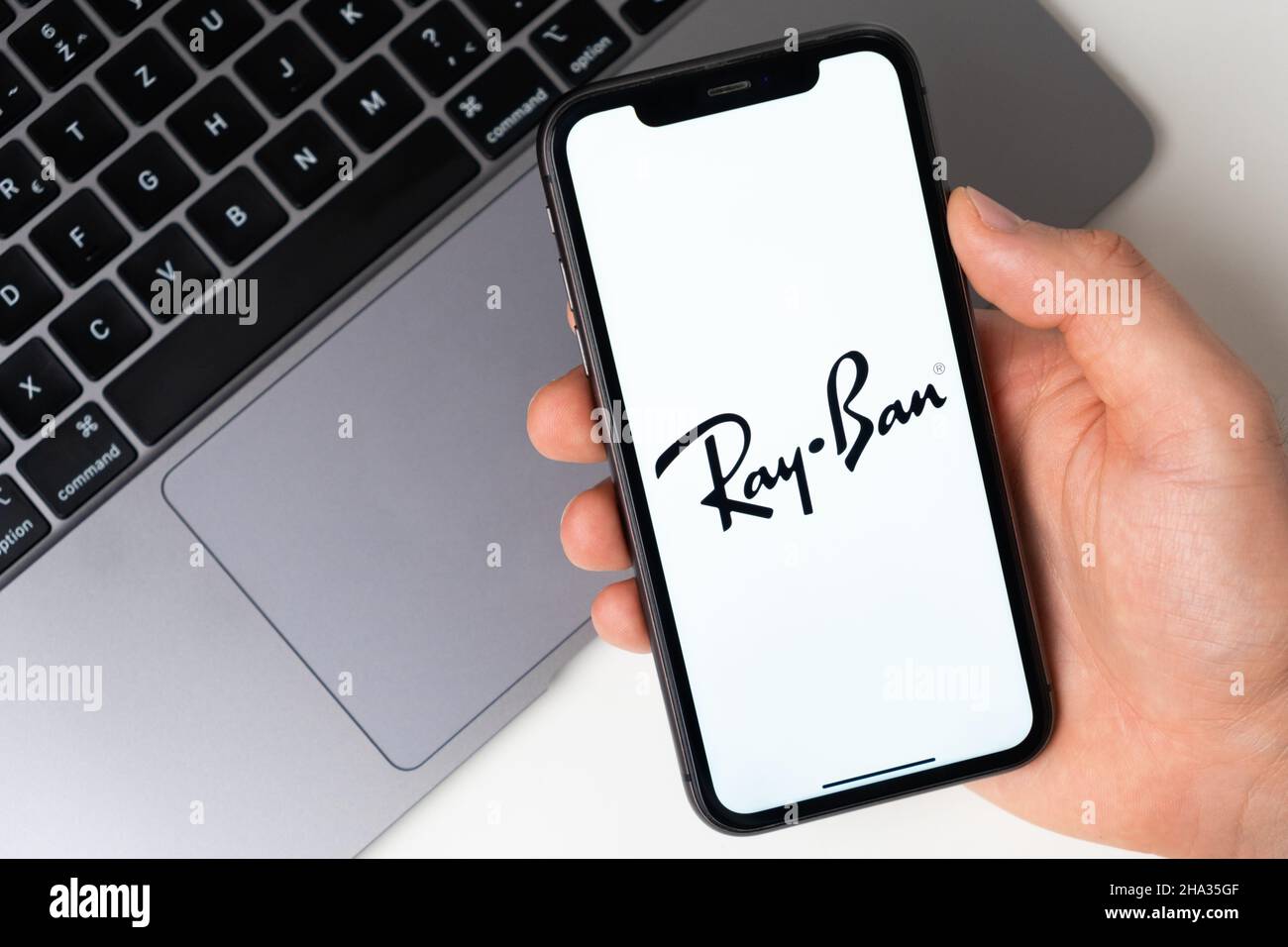 Ray Ban l'applicazione è aperta nello smartphone. L'uomo sta tenendo un telefono cellulare in mano, l'applicazione aziendale è aperta sullo schermo. Acquisti online sicuri. Novembre 2021, San Francisco, USA Foto Stock