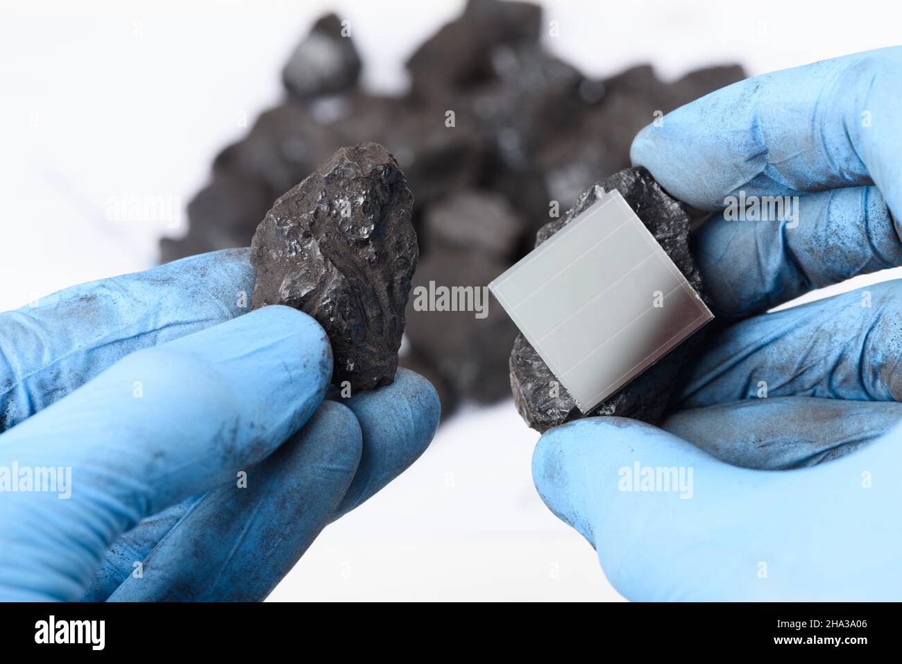 Pannello solare e grumo di carbone nelle mani dello scienziato. Transizione dei combustibili fossili al concetto di riapprovvigionamento delle energie rinnovabili. Foto Stock