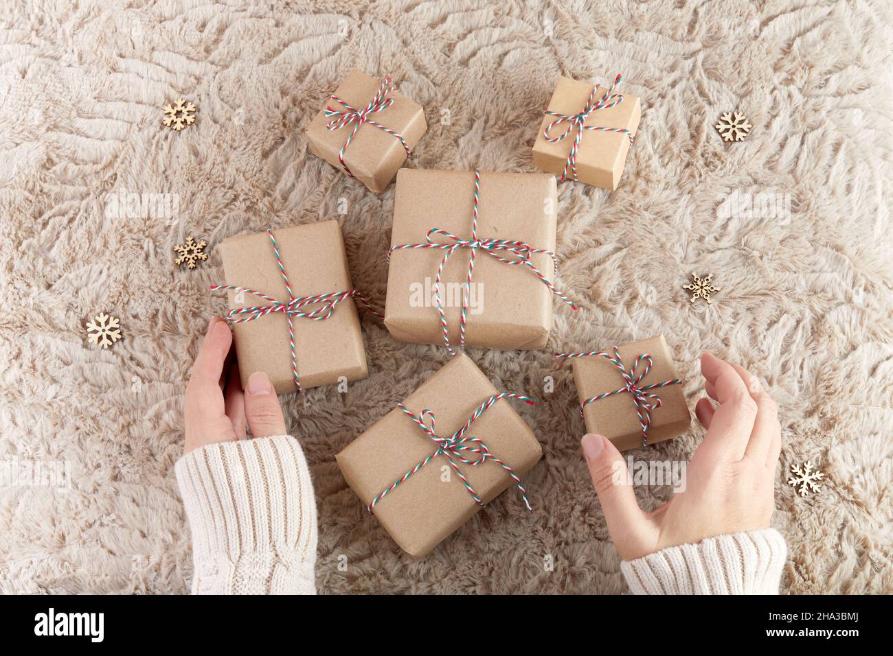 Zero spreco di Natale piatto. Mani che tengono semplice regalo di natale. Stile di vita sostenibile senza plastica Foto Stock