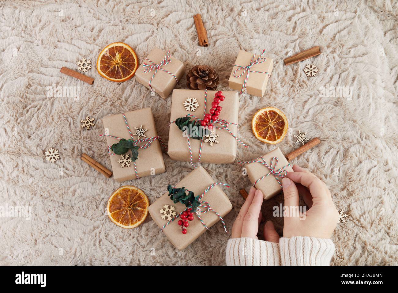 Zero spreco di Natale piatto. Mani che tengono semplice regalo di natale. Stile di vita sostenibile senza plastica Foto Stock