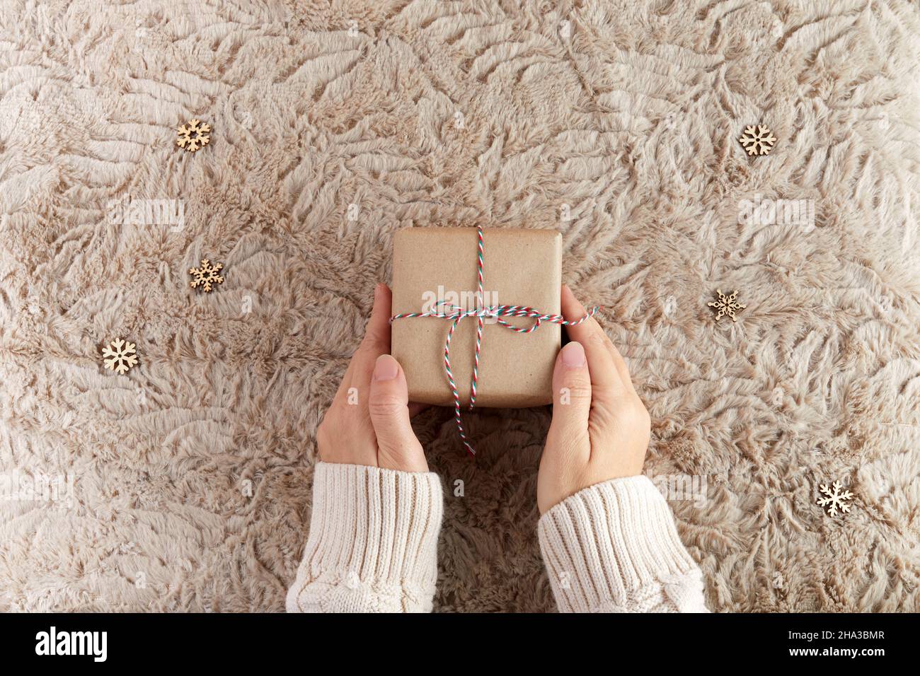 Zero spreco di Natale piatto. Mani che tengono semplice regalo di natale. Stile di vita sostenibile senza plastica Foto Stock