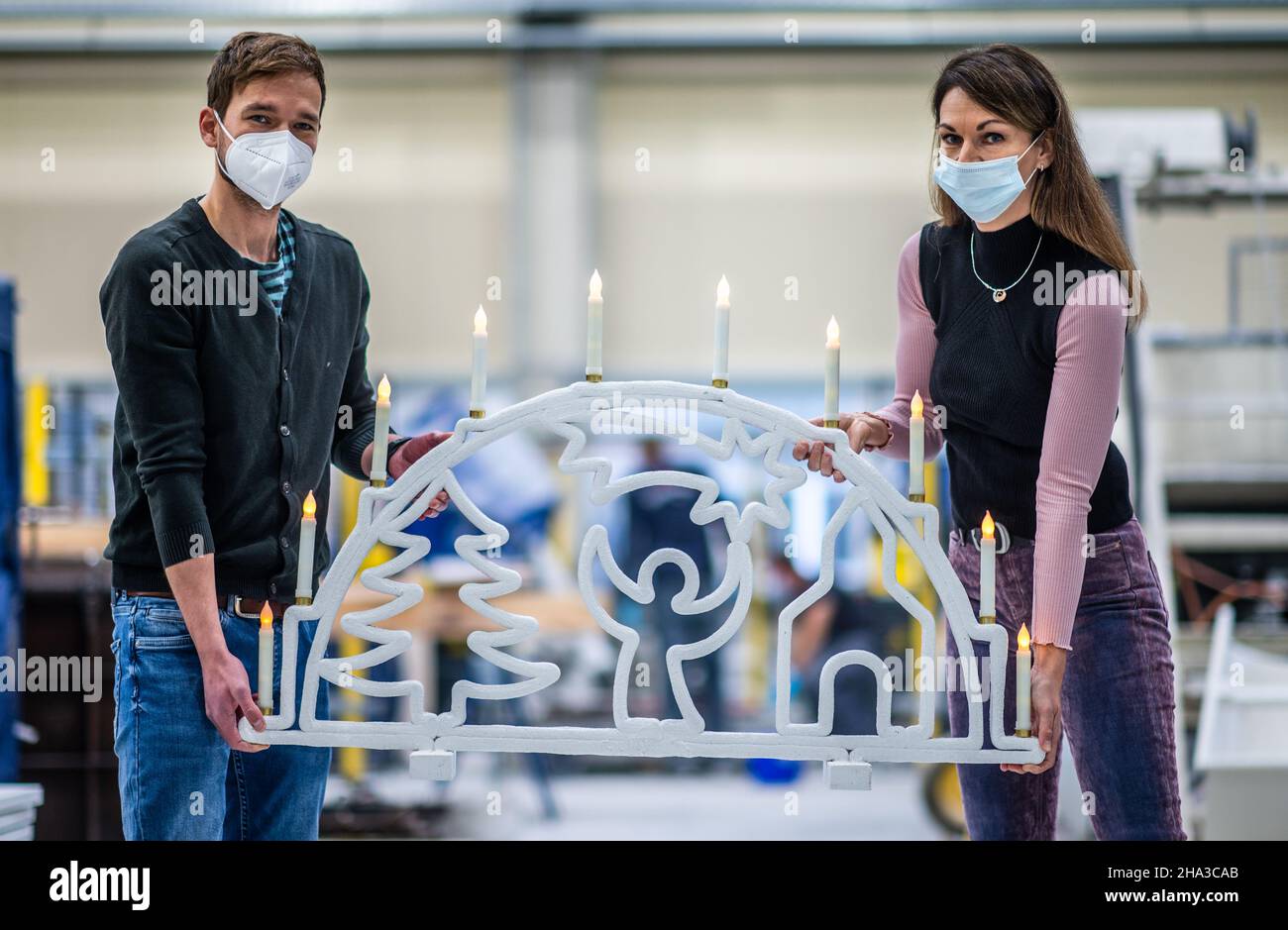 10 dicembre 2021, Sassonia, Chemnitz: Sandra Gelbrich, responsabile dell'area di ricerca "strutture leggere in ingegneria civile" presso tu Chemnitz, e il leader del gruppo di lavoro Enrico Rudolph mostrano un contrafforte volante in calcestruzzo che è stato prodotto utilizzando un processo di stampa automatizzato 3D. Gli scienziati dell'Institute of Lightweight Structures presso la Chemnitz University of Technology ricercano tecnologie automatizzate di produzione di additivi per cinque anni. Recentemente, hanno presentato il primo arco galleggiante in calcestruzzo stampato a 3D° del mondo. Una speciale formula di cemento rinforzato con fibre viene applicata in diversi strati Foto Stock