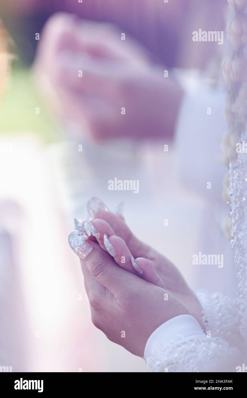 Sposi e sposi le mani quando pregano. Foto Stock