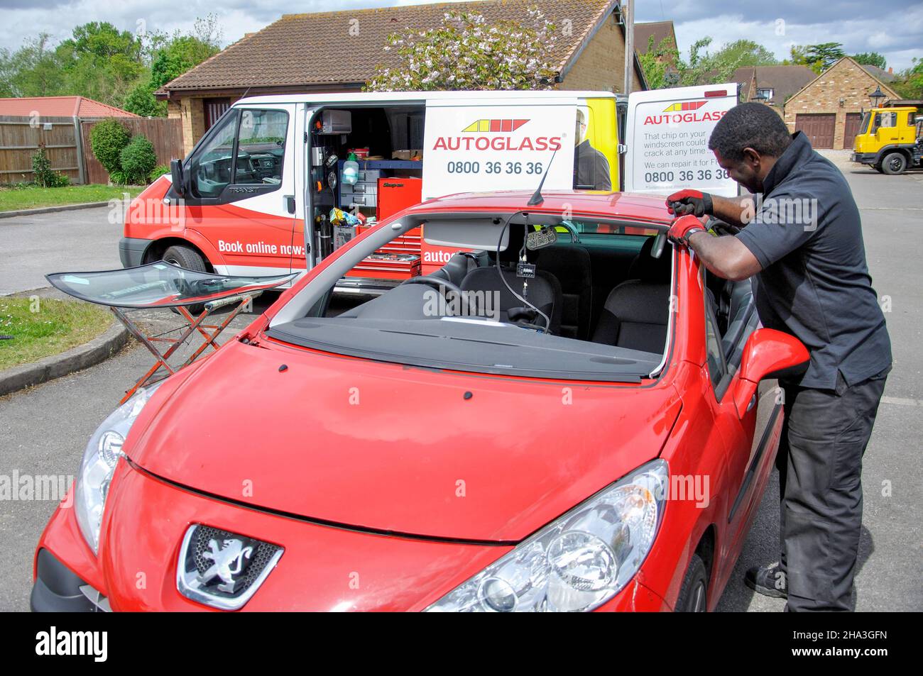 Parabrezza auto essendo sostituito da Autoglass uomo, Stanwell Moor, Staines Middlesex, England, Regno Unito Foto Stock