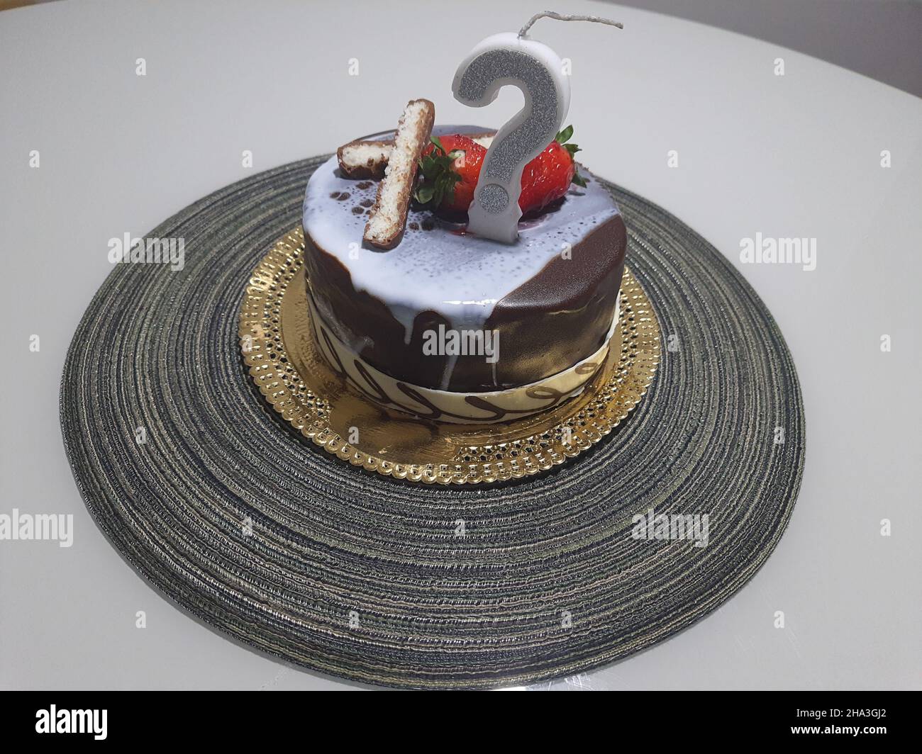 Torta di compleanno al cioccolato con glassa al cioccolato e candela con punto interrogativo. Foto Stock