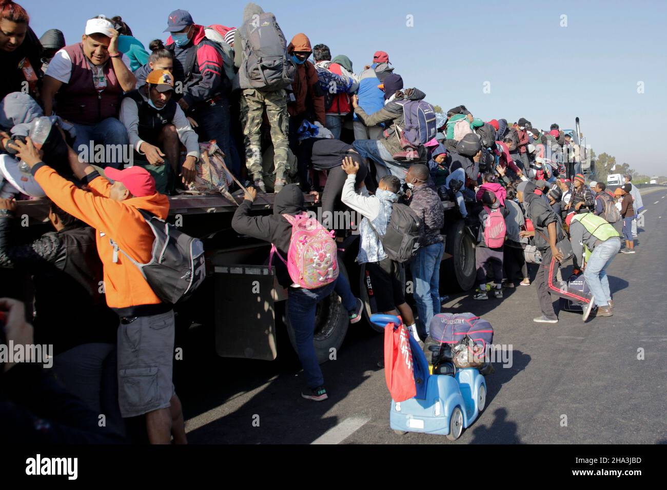 Puebla, Messico. 9th Dic 2021. I migranti che prendono parte a una roulotte salgono a bordo di un camion sull'autostrada Puebla-Mexico, nello stato di Puebla, Messico, il 9 dicembre 2021. Una carovana migrante continua il suo corso attraverso lo stato di Puebla, durante il suo viaggio attraverso il territorio messicano verso il confine con gli Stati Uniti. Credit: Dario/Dario/Alamy Live News Foto Stock