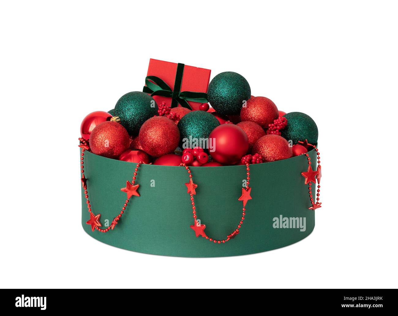 Decorazioni natalizie in una scatola isolata su sfondo bianco. Decorazioni natalizie rosse e verdi. Stoccaggio di accessori per le vacanze. Foto Stock