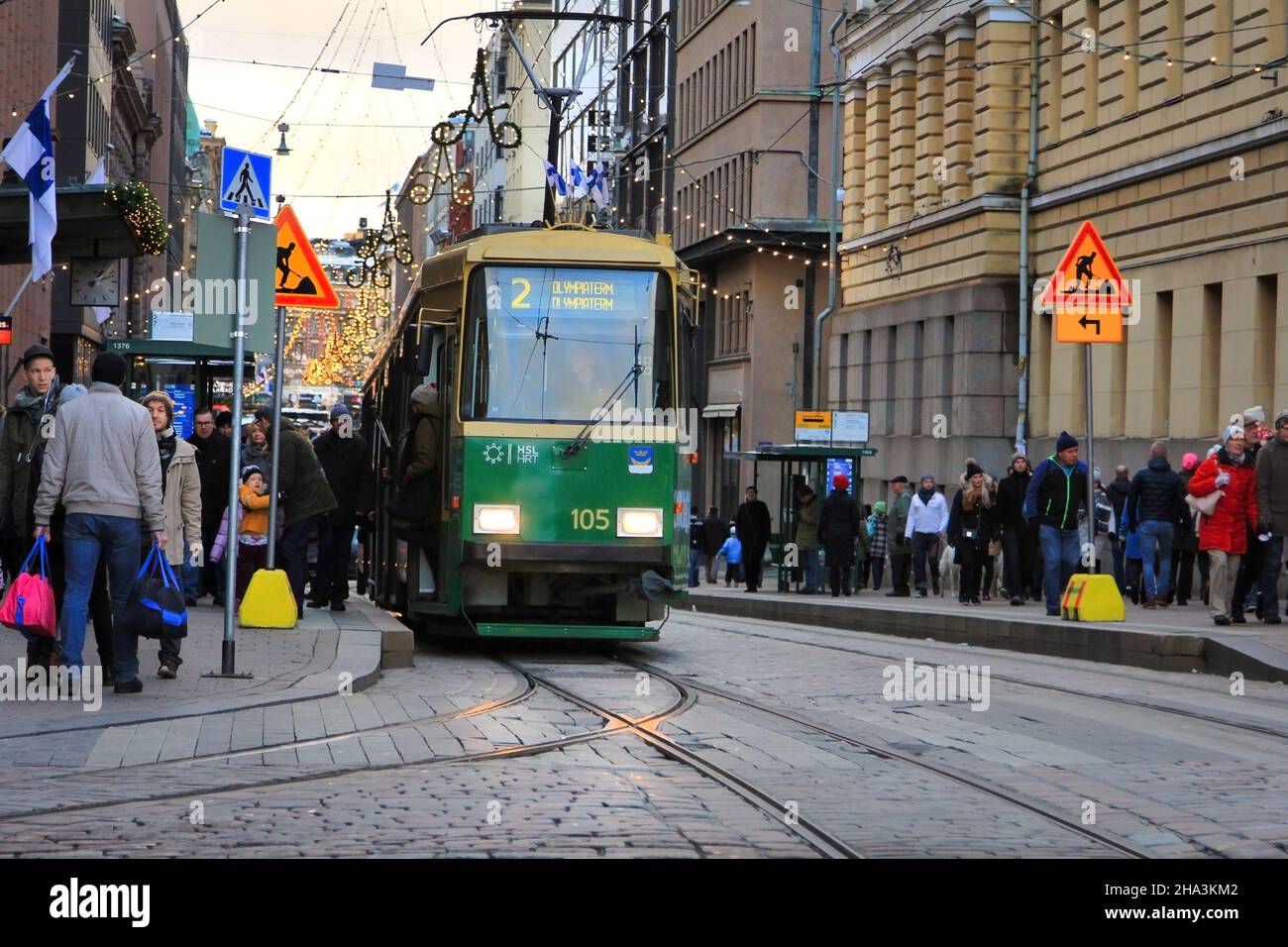 Gli amanti dello shopping e i viaggiatori nell'affollata Aleksanterinkatu con il tram Green HSL alla fermata Senaatintori. Helsinki, Finlandia. Dicembre 6, 2017. Foto Stock