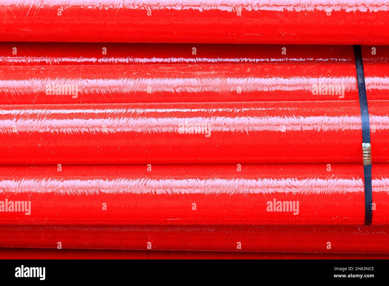 Tubi in fibra di vetro rossa in cantiere, tubi compositi in fibra di vetro resistente alla corrosione utilizzati nelle applicazioni industriali. Foto Stock