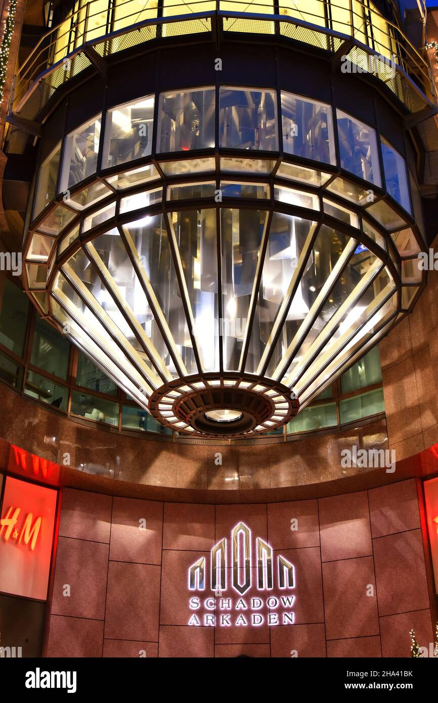 Moderno cilindro di vetro illuminato all'ingresso del centro commerciale 'Schadow-Arkaden' nel centro di Düsseldorf vicino a Königsallee. Foto Stock
