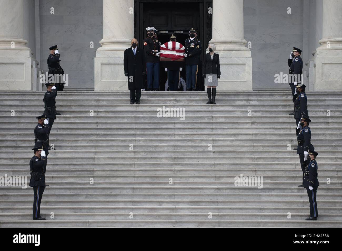 Washington, Stati Uniti. 10th Dic 2021. Gli ufficiali della polizia del Campidoglio degli Stati Uniti stanno all'attenzione come sergente del Senato ad Arms Karen Gibson (R) e sergente della Camera ad Arms William J. Walker (L) guidano una guardia militare d'onore di servizi congiunti mentre trasportano la cassa del senatore ritardato Robert Dole (R-KS) giù i passi del Campidoglio degli Stati Uniti Dopo essere stato in stato il 10 dicembre 2021 a Washington, DC. Pool Photo by Anna Moneymaker/UPI Credit: UPI/Alamy Live News Foto Stock