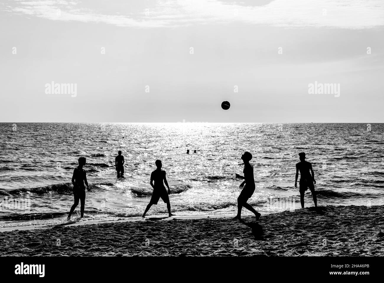 Amici felici che giocano a calcio sulla spiaggia al tramonto - silhouette di teen amici che giocano a calcio sulla spiaggia durante le vacanze estive - irriconoscibile reale Foto Stock