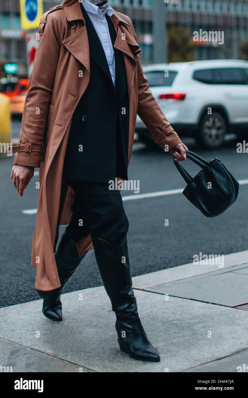 Figura ritagliata di donna in lungo autunno marrone cappotto di pelle e nero Blazer camminare in città. Street style, moda femminile casual Foto Stock