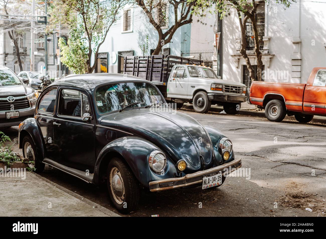 CITTÀ DEL MESSICO, MESSICO - Nov 08, 2021: Un classico VW Beetle (vocho) e camion parcheggiati nel quartiere di Roma Norte. Foto Stock