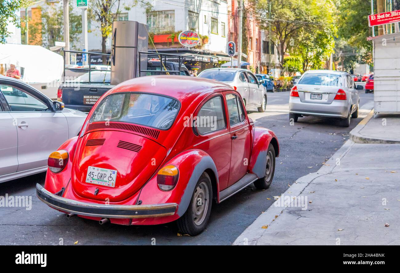 CITTÀ DEL MESSICO, MESSICO - Nov 08, 2021: Un classico rosso VW Beetle (vocho) e il traffico nel quartiere di Roma Norte Foto Stock
