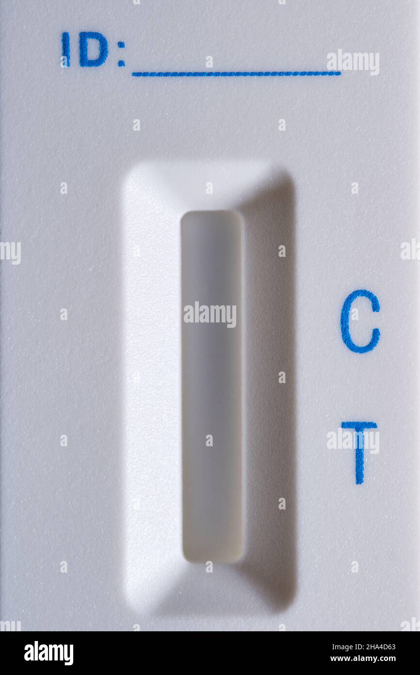 Dettaglio della cassetta per test dell'antigene Covid-19 in plastica bianca senza risultato del test. Lettere blu e striscia rossa. Riga spazio ID. Vista frontale. Primo piano. Mac Foto Stock