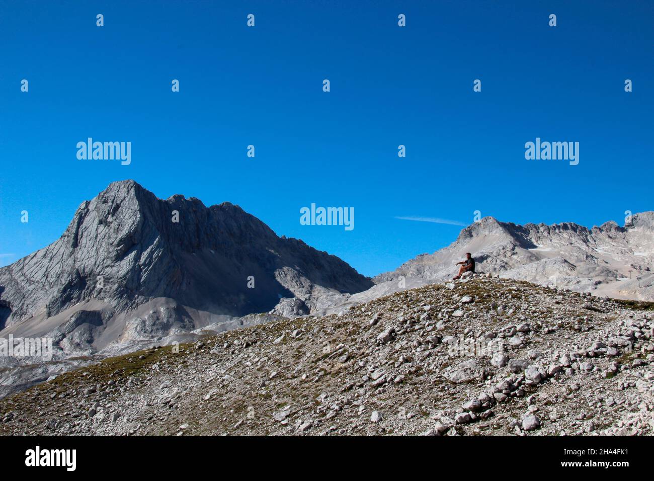 uomo di mezza età in un'escursione alla zugspitze 2962 m, a sinistra nella foto la plattspitze orientale (2679m), wetterstein montagne garmisch-partenkirchen, alta baviera, baviera, germania meridionale, germania, europa, Foto Stock
