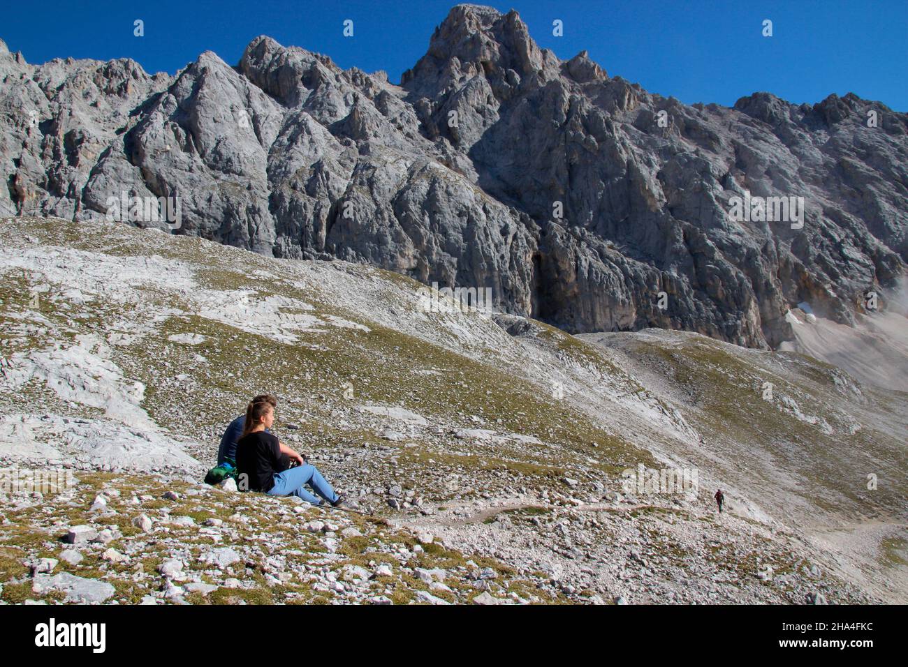 la giovane coppia fa una pausa durante un'escursione alla zugspitze 2962 m, sullo sfondo la jubiläumsgrat con la höllentalspitze interna 2737m, wetterstein montagne garmisch-partenkirchen, alta baviera, baviera, germania meridionale, germania, europa, Foto Stock