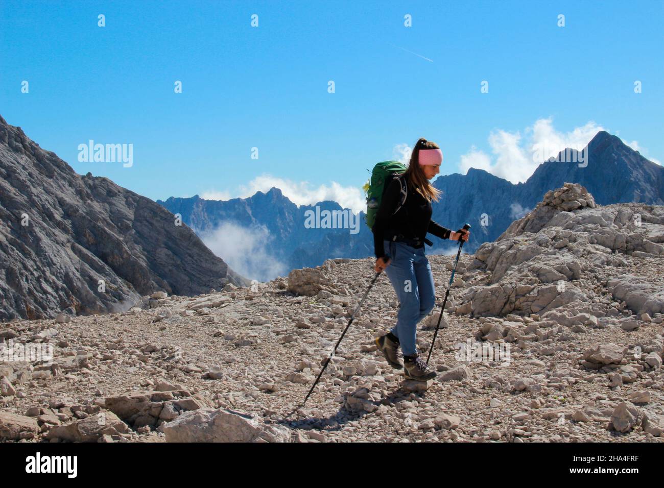 giovane donna in escursione a zugspitze 2962 m, a destra nella foto l'hochwanner 2744 m, wetterstein montagne garmisch-partenkirchen, alta baviera, baviera, germania meridionale, germania, europa, Foto Stock
