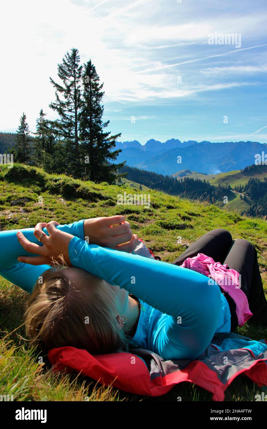 la giovane donna fa una pausa durante un'escursione a geigelstein (1808m), riserva naturale, aschau im chiemgau, alta baviera, baviera, germania Foto Stock