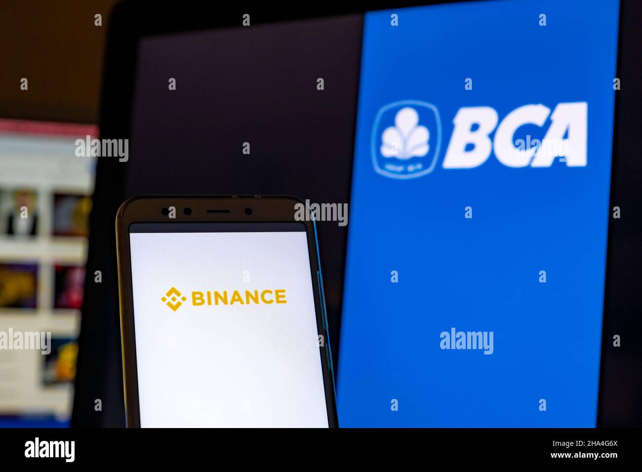 In questa foto il logo Binance viene visualizzato sullo schermo di uno smartphone con il logo della Banca Centrale dell'Asia sullo sfondo. Foto Stock