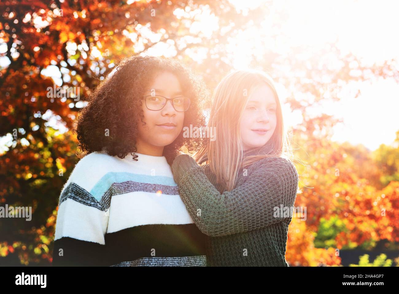 Due ragazze graziose di Tween retroilluminate nei colori di caduta. Foto Stock