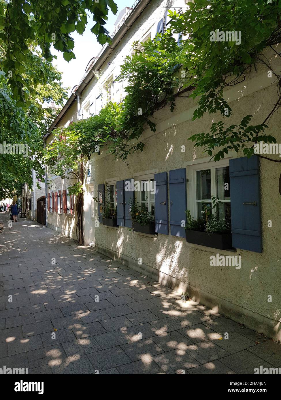 haidhausen, strada piccola romantica, case basse con persiane blu, un gioiello del villaggio, ex un luogo di residenza per i poveri, oggi una ricercata zona residenziale Foto Stock