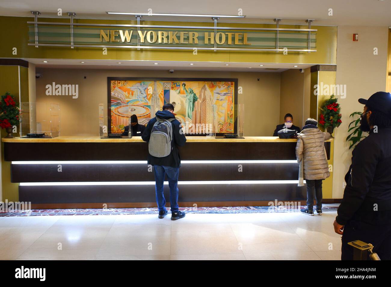 I clienti che effettuano il check-in presso la reception nella hall dello storico New Yorker Hotel by Wyndham a Midtown Manhattan.New York City.New York.USA Foto Stock