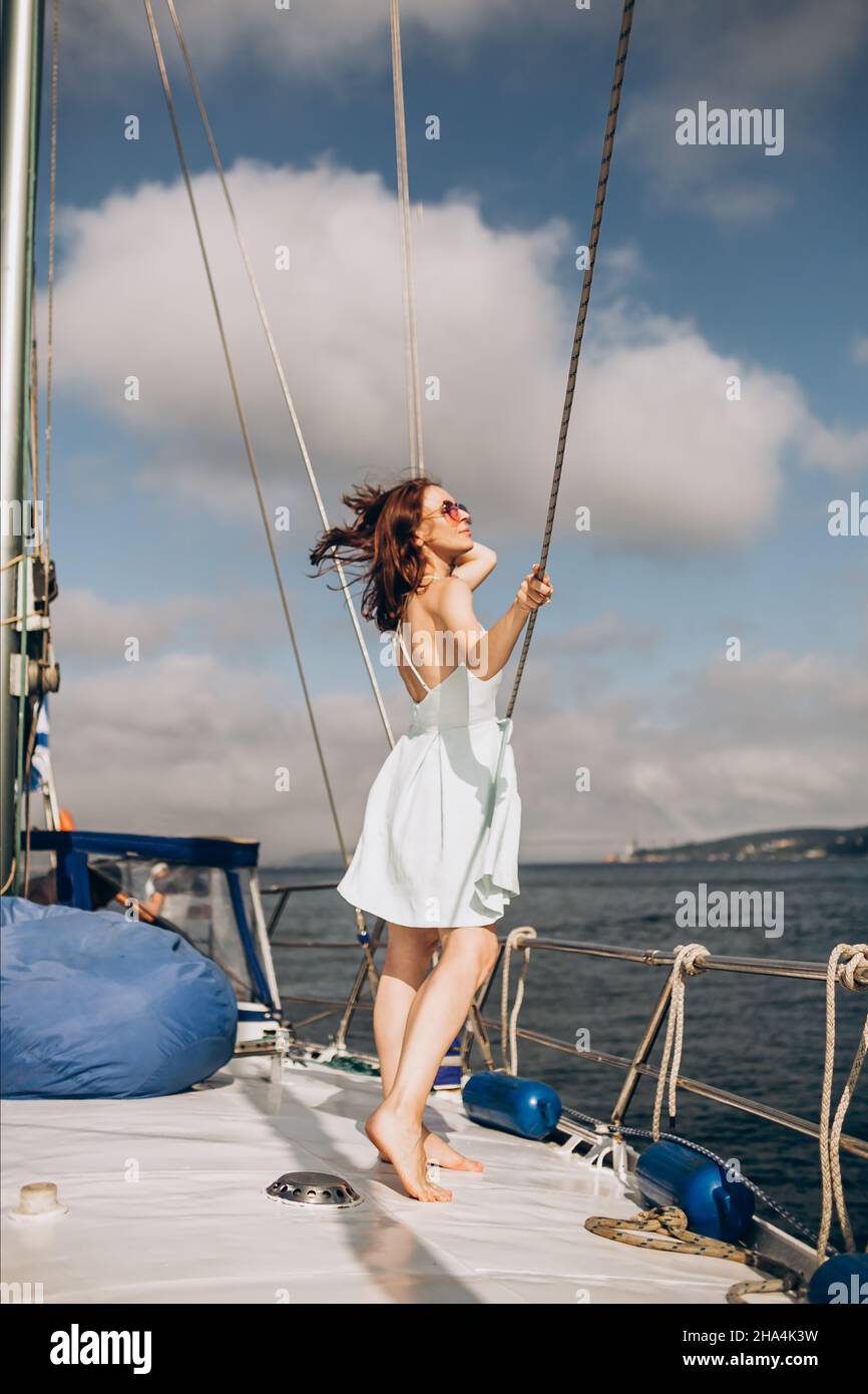 Donna in piedi sul ponte dello yacht lo sfondo del cielo Foto Stock