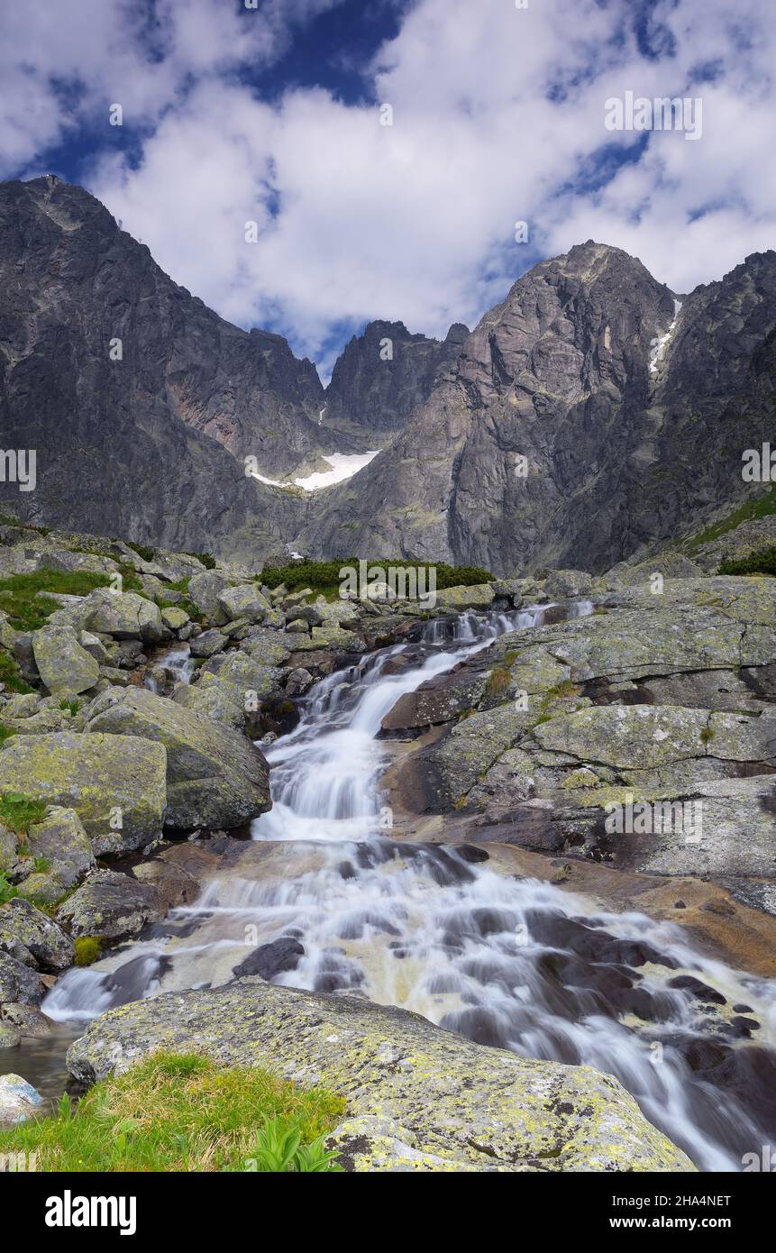 Paesaggio di montagna con un torrente tra pietre. Vista sulla cima del picco Lomnicky Foto Stock