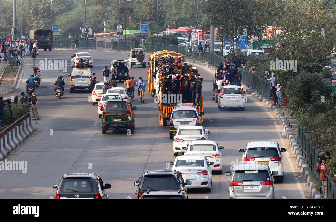 New Delhi, India. 10th Dic 2021. I funzionari dell'esercito scortano il veicolo coperto di fiori che trasportano i resti mortali del Capo dello Stato maggiore della Difesa (CDS) Generale Bipin Rawat trasportato in un luogo funebre durante la processione funebre.Generale Bipin Rawat, Sua moglie Madhulika e altri 11 membri del personale delle forze armate hanno perso la vita in un incidente dell'elicottero dell'aviazione indiana mi-17V5 a Coonoor, Tamil Nadu. CDS Bipin Rawat cremato con pieni onori militari alla Bar Square di Delhi Cantonmet. Credit: SOPA Images Limited/Alamy Live News Foto Stock