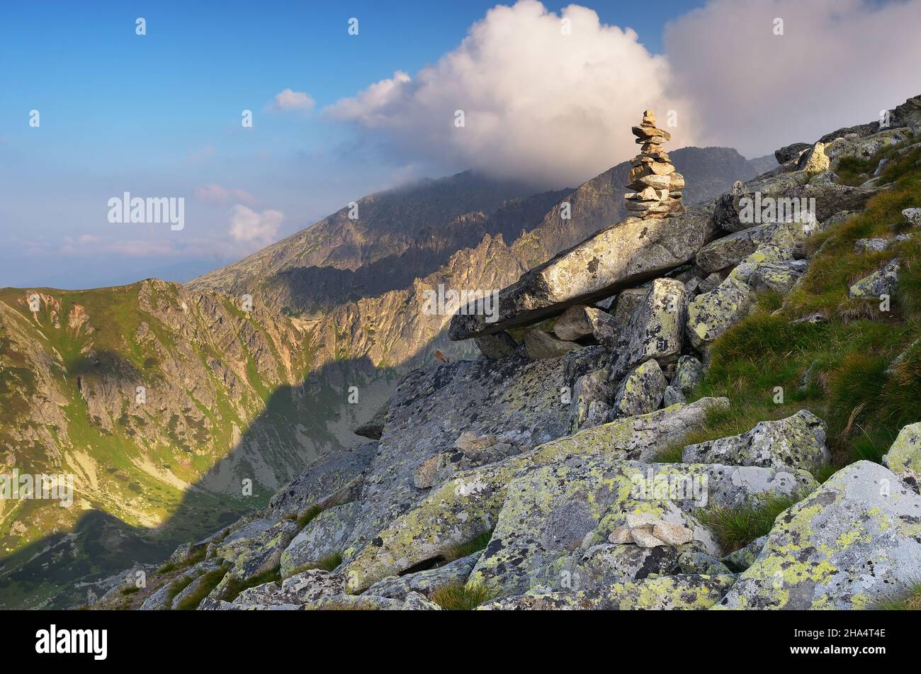 Paesaggio di alta montagna con rocce e scogliere circondate da splendide nuvole Foto Stock