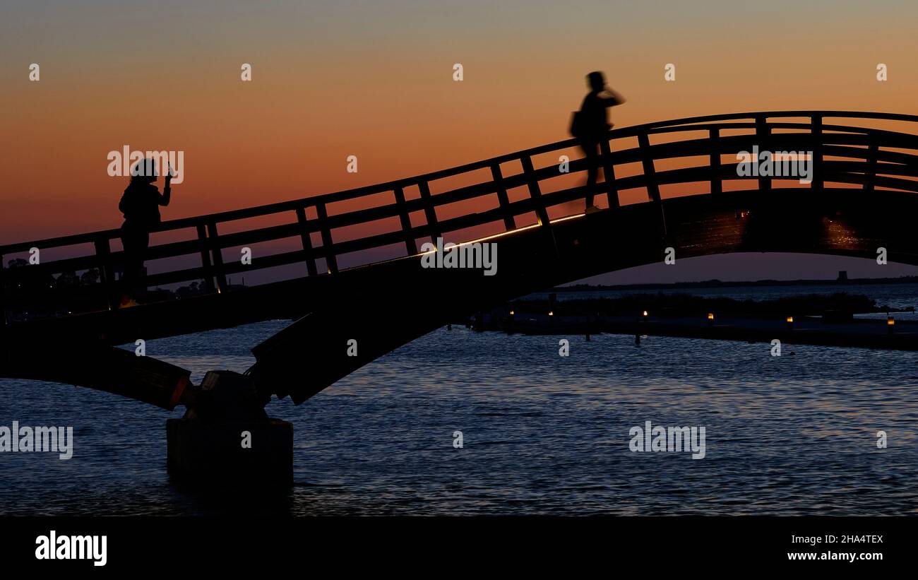 grecia,isole greche,isole ionie,lefkada o lefkas,lefkada città,capitale,crepuscolo,atmosfera serale,tramonto,ponte di legno,ponte,su di esso due persone come una silhouette,una fotografando l'altra,arancio cielo Foto Stock