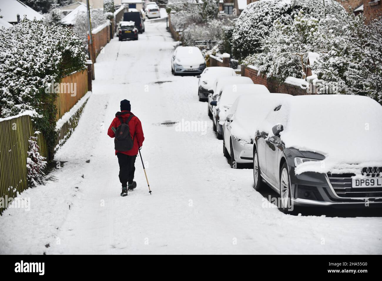 Vista posteriore della donna che cammina lungo Hodge Bower, Ironbridge nella neve inverno 2021 gennaio Foto Stock