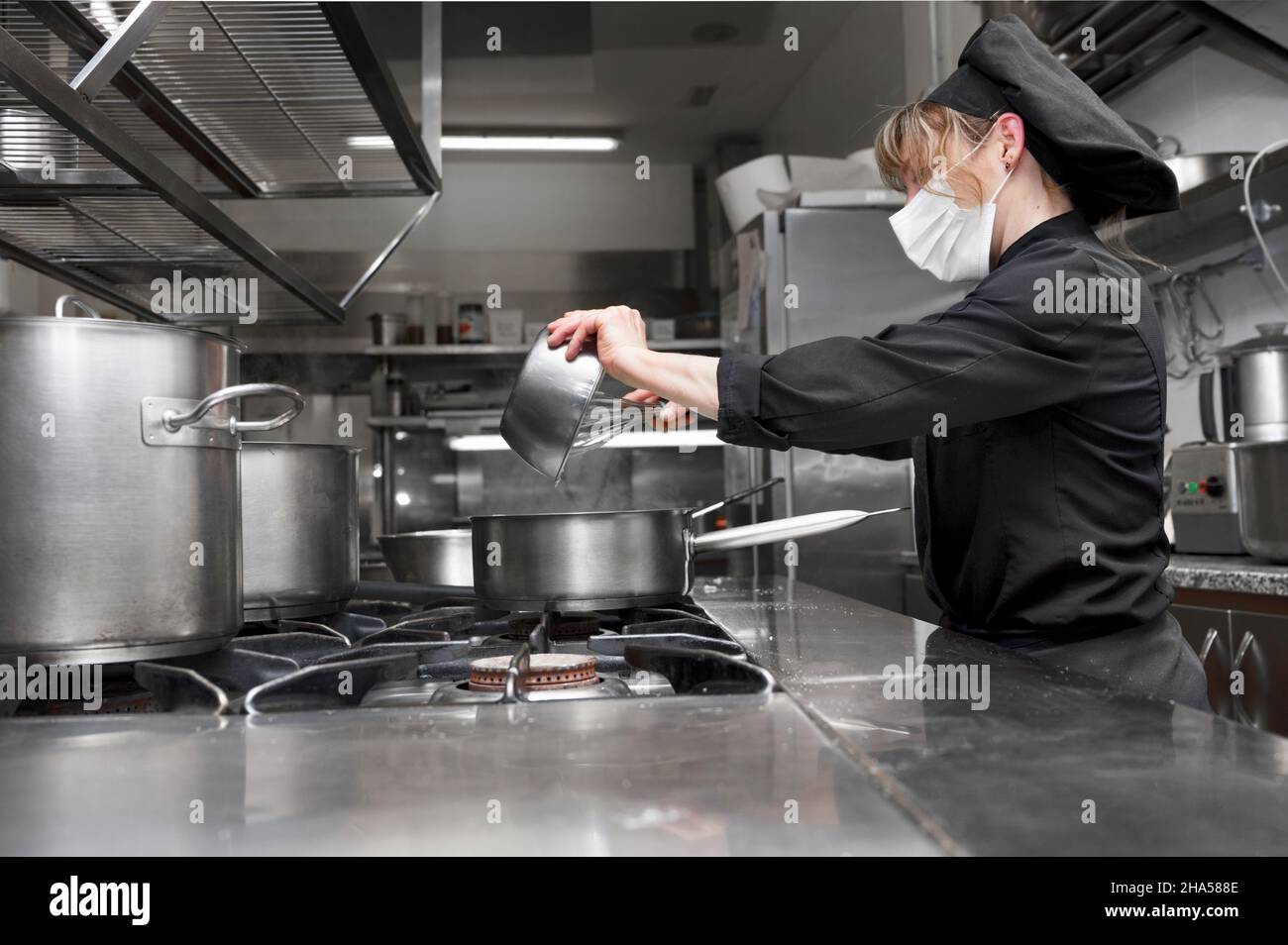 Ritratto di fiducioso chef femminile che lavora in cucina commerciale. Foto di alta qualità Foto Stock