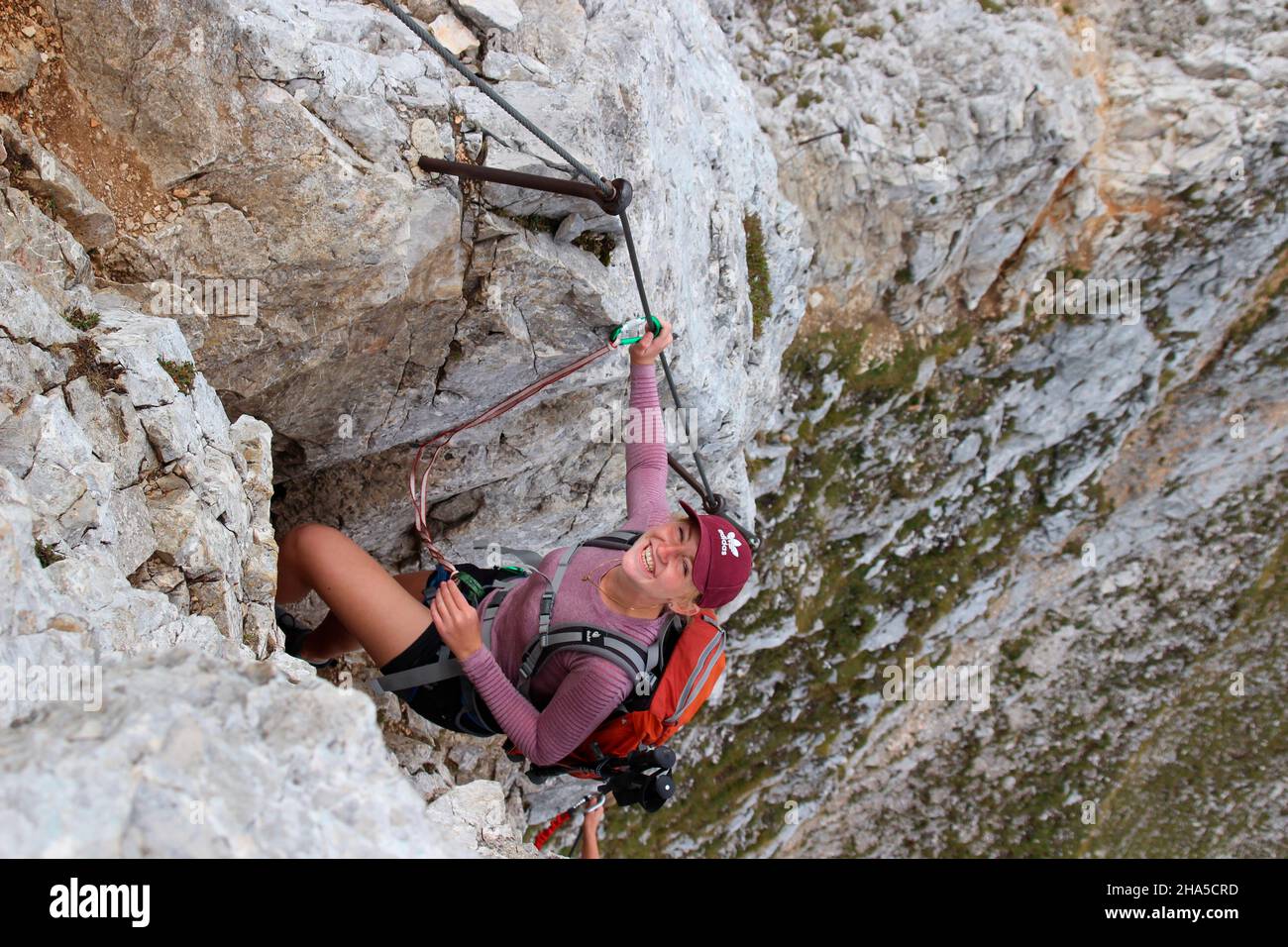 la giovane donna ride nella macchina fotografica, durante un tour di montagna sul mittenwalder höhenweg al brunnsteinspitze, germania, baviera, alta baviera, mittenwald, Foto Stock