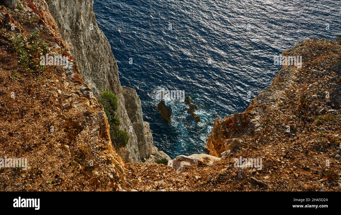 grecia,isole greche,isole ionie,lefakada o lefkas,punta meridionale dell'isola,costa ripida,capo lefkadas,luce del pomeriggio,vista dalla costa ripida in basso,rocce scoscese,rocce in acqua,surf,sole scintillante sul mare Foto Stock