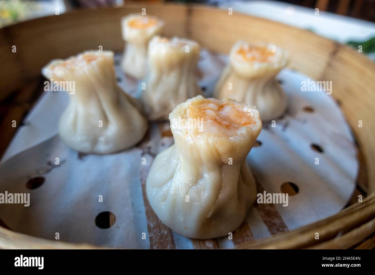 Vista ravvicinata dei gnocchi di gamberi e kurobuta di maiale shao mai all'interno di un cestino di vaporetti in un ristorante Foto Stock