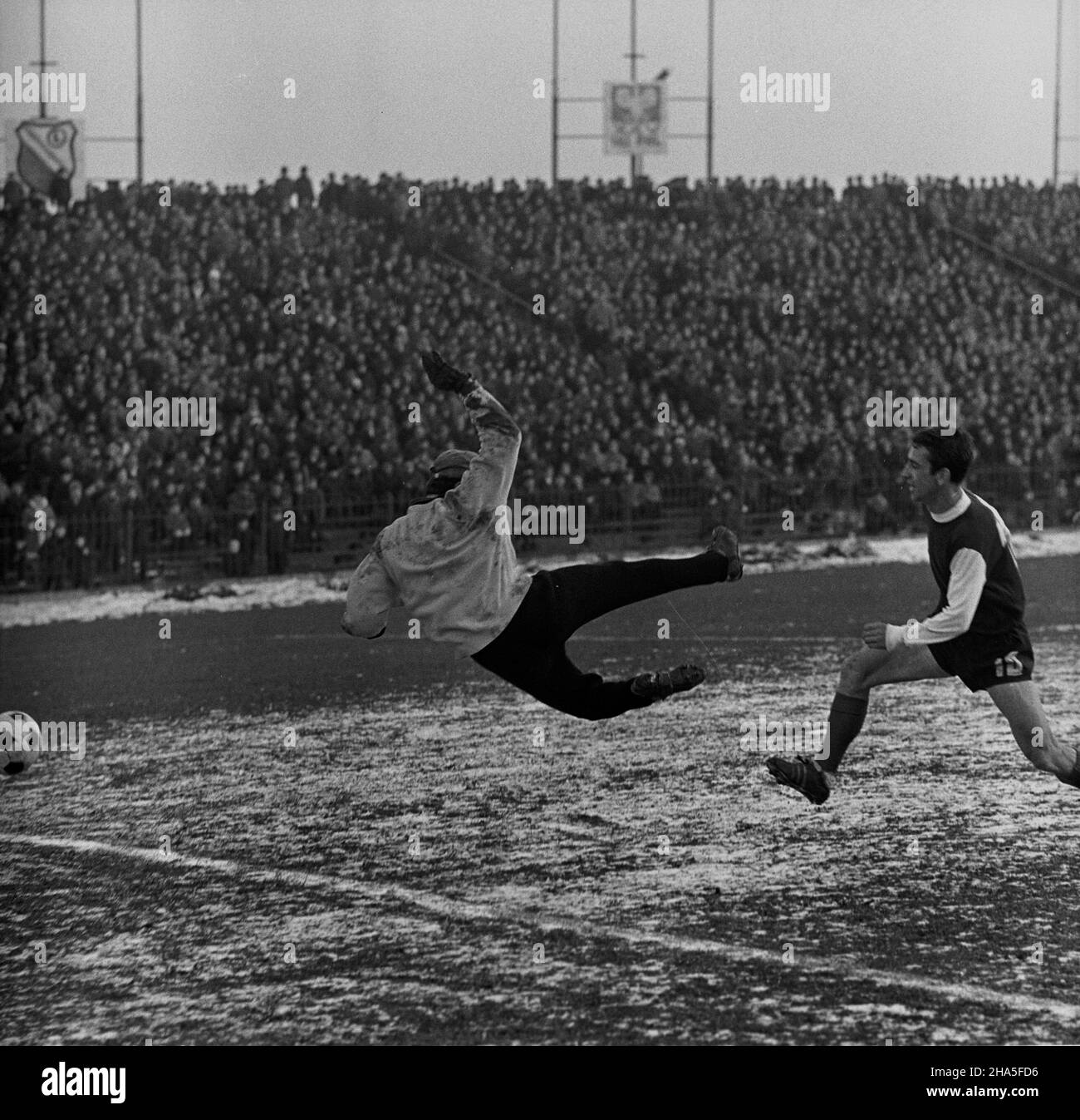 Warszawa, 1969-11-30. Mecz Legia Warszawa - Ruch Chorzów na Stadionie Wojska Polskiego przy ulicy £azienkowskiej, rozegrany podczas ostatniej kolejki rundy jesiennej sezonu 1969/1970. Mecz zakoñczy³ siê zwyciêstwem Legii 3:0, co da³o warszawskiemu klubowi tytu³ mistrza rundy jesiennej. Bramki strzelili: Jan Pieszko - dwie i Bernard Blaut - jedn¹. NZ. Pomocnik Legii Jan Pieszko (1P) strzela bramkê. Bramkarz Ruchu Henryk Pietrek (1L) usi³uje obroniæ strza³. mb PAP/Edmund Uchymiak Varsavia, 30 novembre 1969. Una partita di calcio tra Legia Warszawa e Ruch Chorzow allo Stad del Legia Military Club Foto Stock