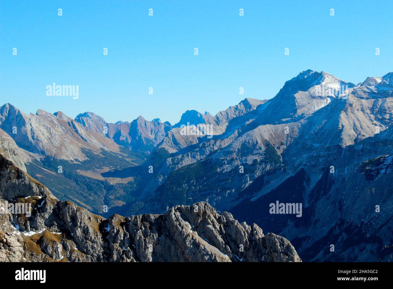 vista dal panoramaweg passamani (germania,zona di confine) nel carwendeltal austriaco con le vette di montagna schiaccianti, a partire dalla grafenkarspitze fino al marxenkarspitze all'estrema destra nella foto, all'ombra il carwendelhaus Foto Stock