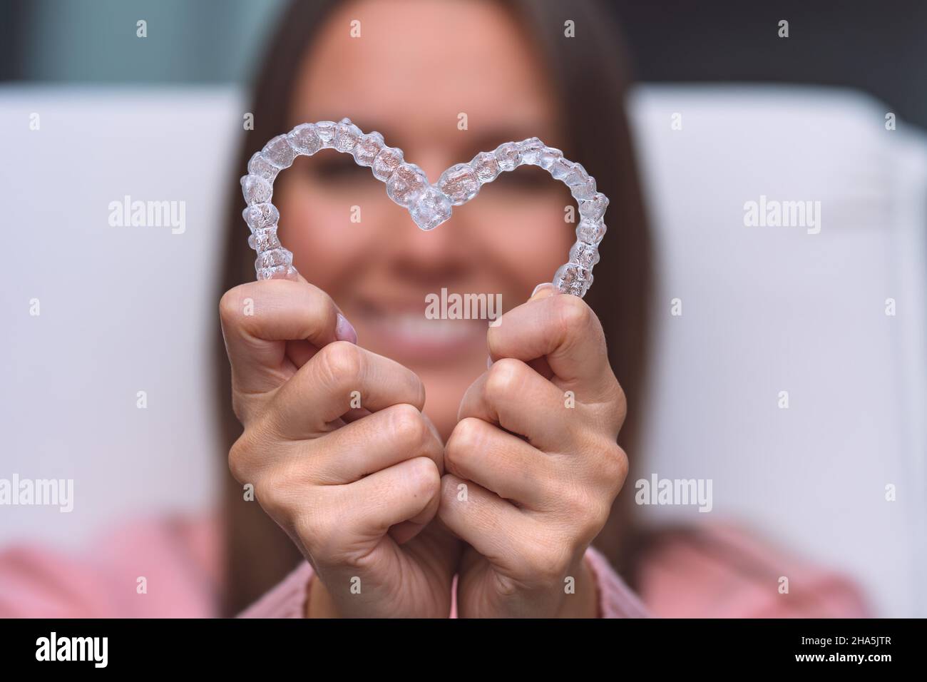 Donna con tutori dentali invisalign invisibili o allenatore di silicone. Trattamento degli allineatori Foto Stock