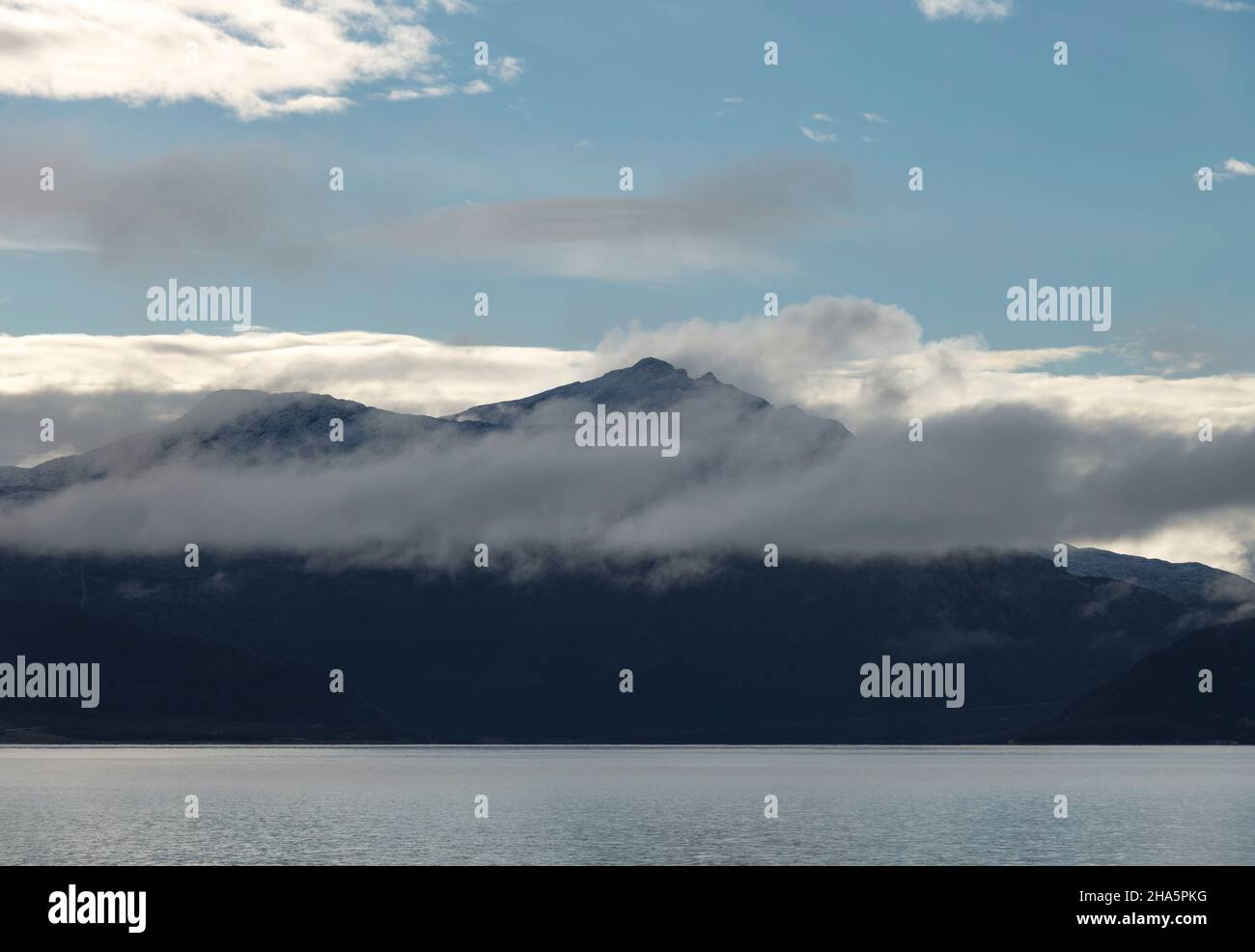 nuvole di fronte a una catena montuosa sul mare nord, nordland, norvegia Foto Stock