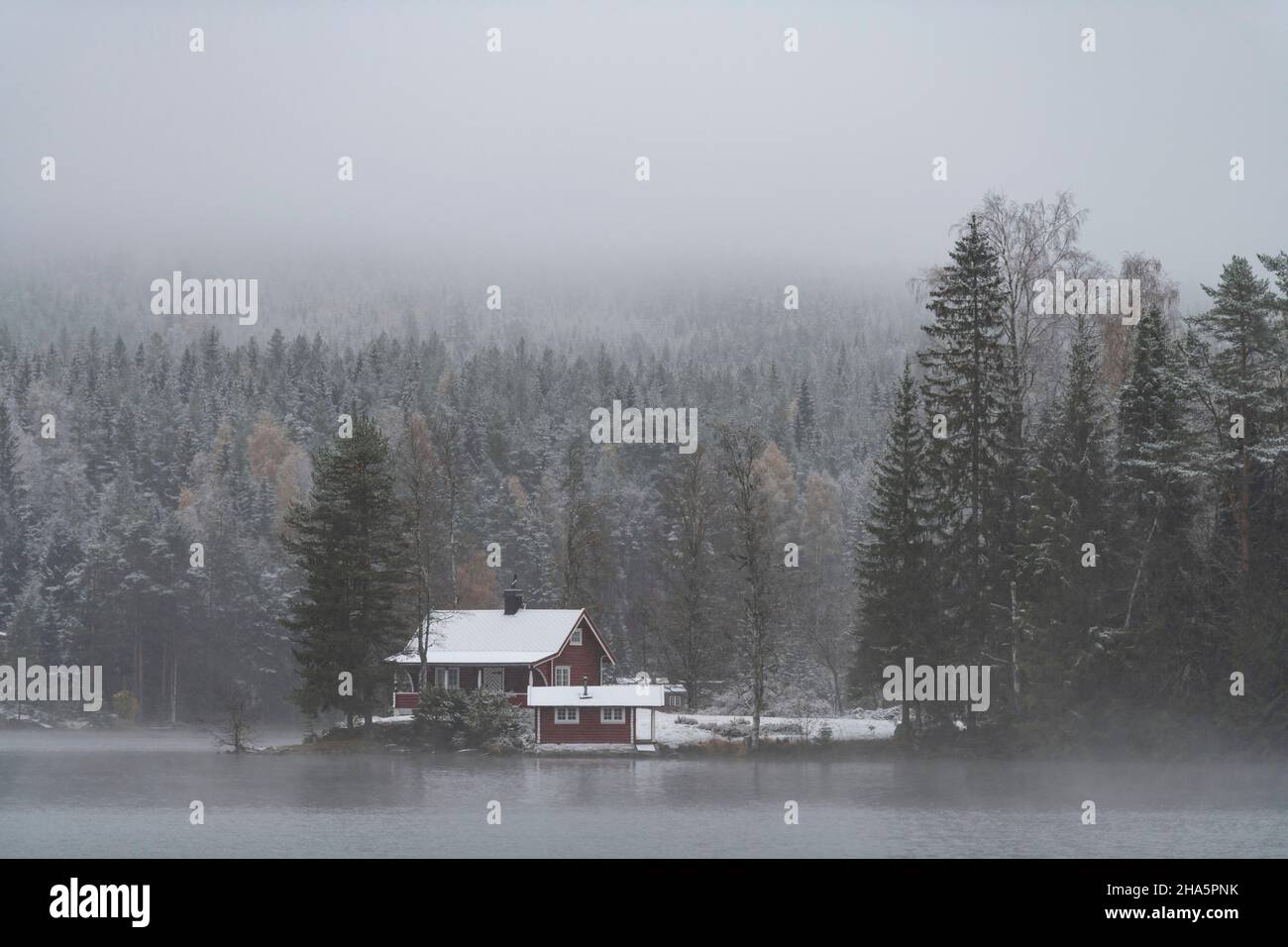 rifugio vicino al lago bæreia nella foresta, nuvole scure, neve, kongsvinger, norvegia Foto Stock