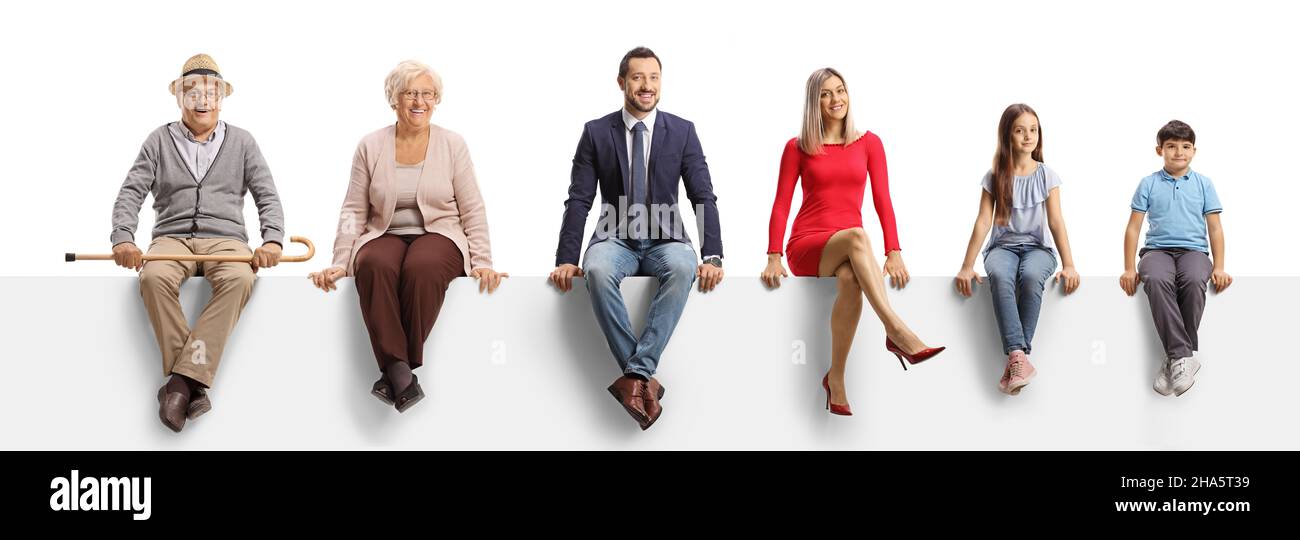 Una famiglia di tre generazioni seduta su un pannello vuoto e sorridente a fotocamera isolato su sfondo bianco Foto Stock