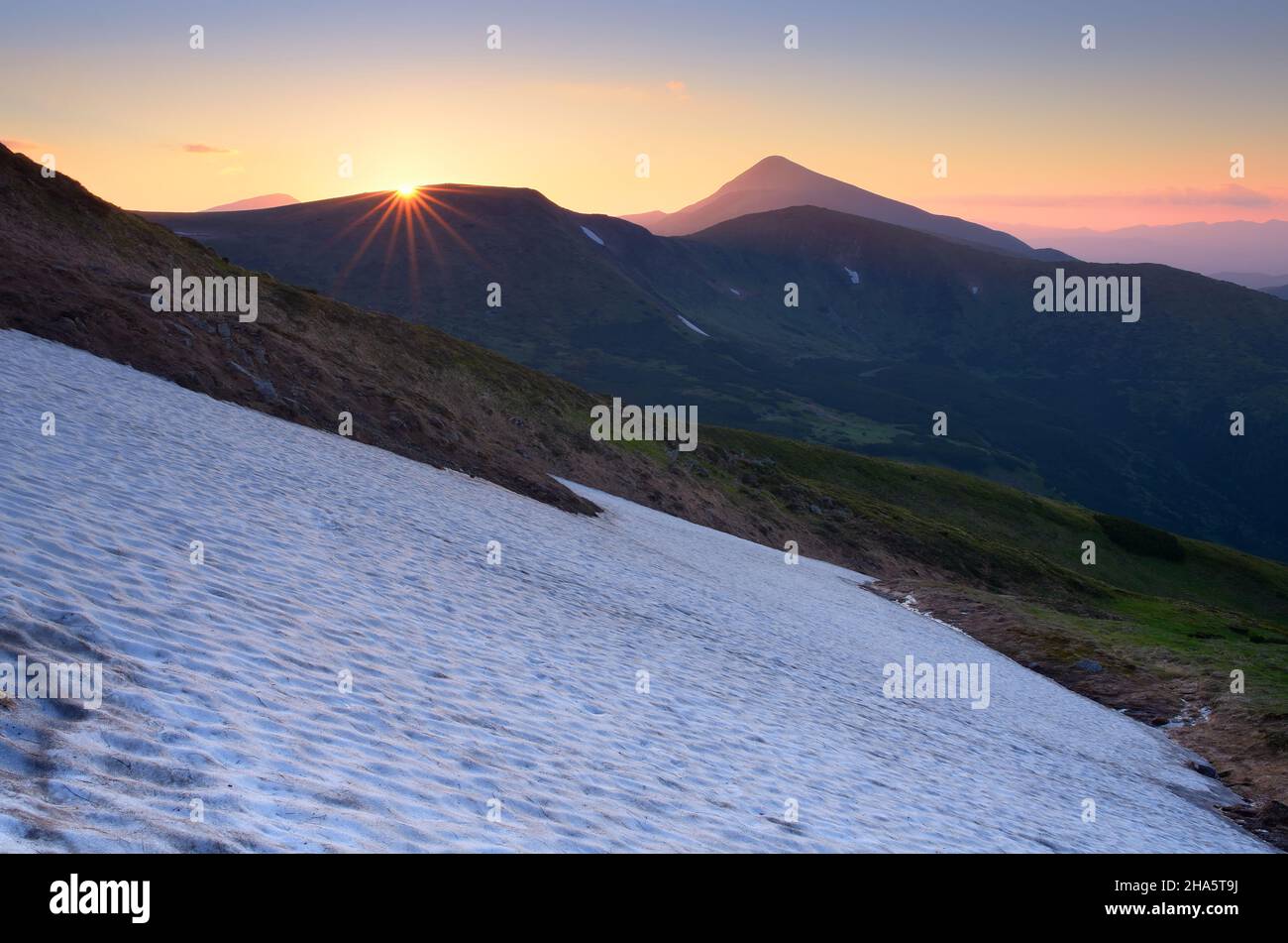 Ultimi raggi del sole tramontare in montagna. Foto Stock