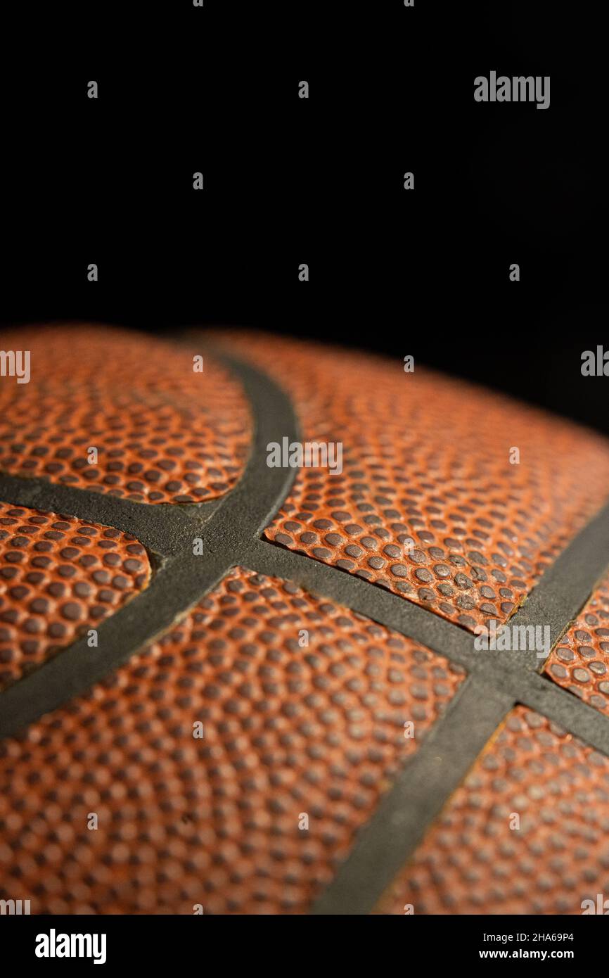 Dettaglio palla da basket arancione con sfondo nero. Foto Stock