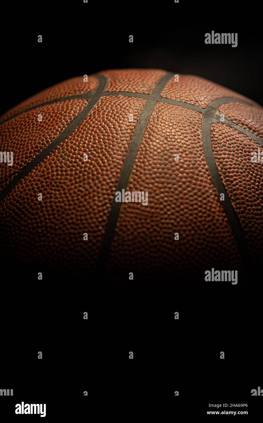 Dettaglio palla da basket arancione con sfondo nero. Foto Stock